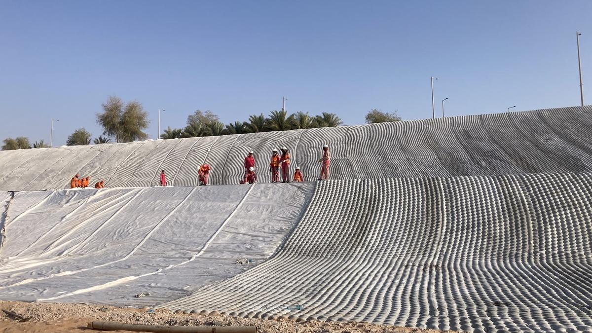 La cuadrilla desplegada sobre el canal revestido, en el desierto