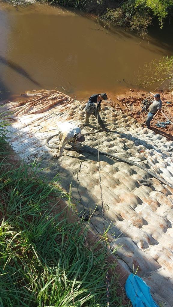 Operarios bombeando el colchón, con el agua del arroyo