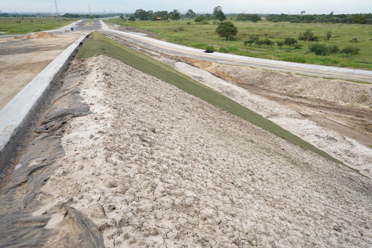 El terraplén con la cuneta de hormigón y el talud verde