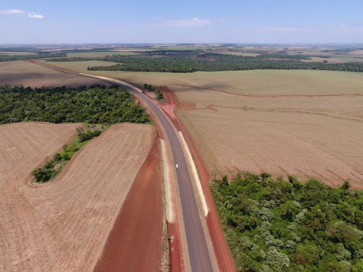 Aérea del terraplén de tierra roja cruzando los campos