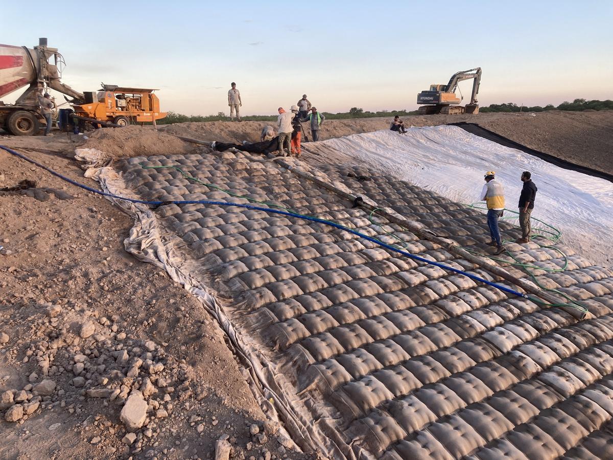 La colocación del colchón con la excavadora y la cuadrilla