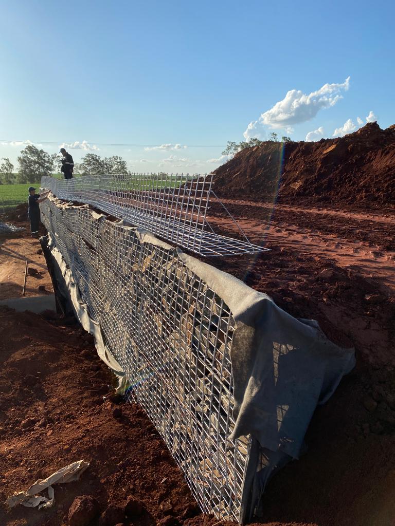 El muro en construcción con la cargadora al fondo