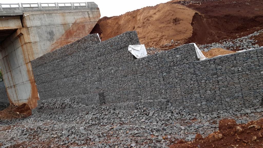 El muro de gaviones bajo el tablero del puente