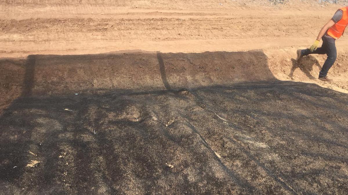 Operario subiendo por el talud recién tratado